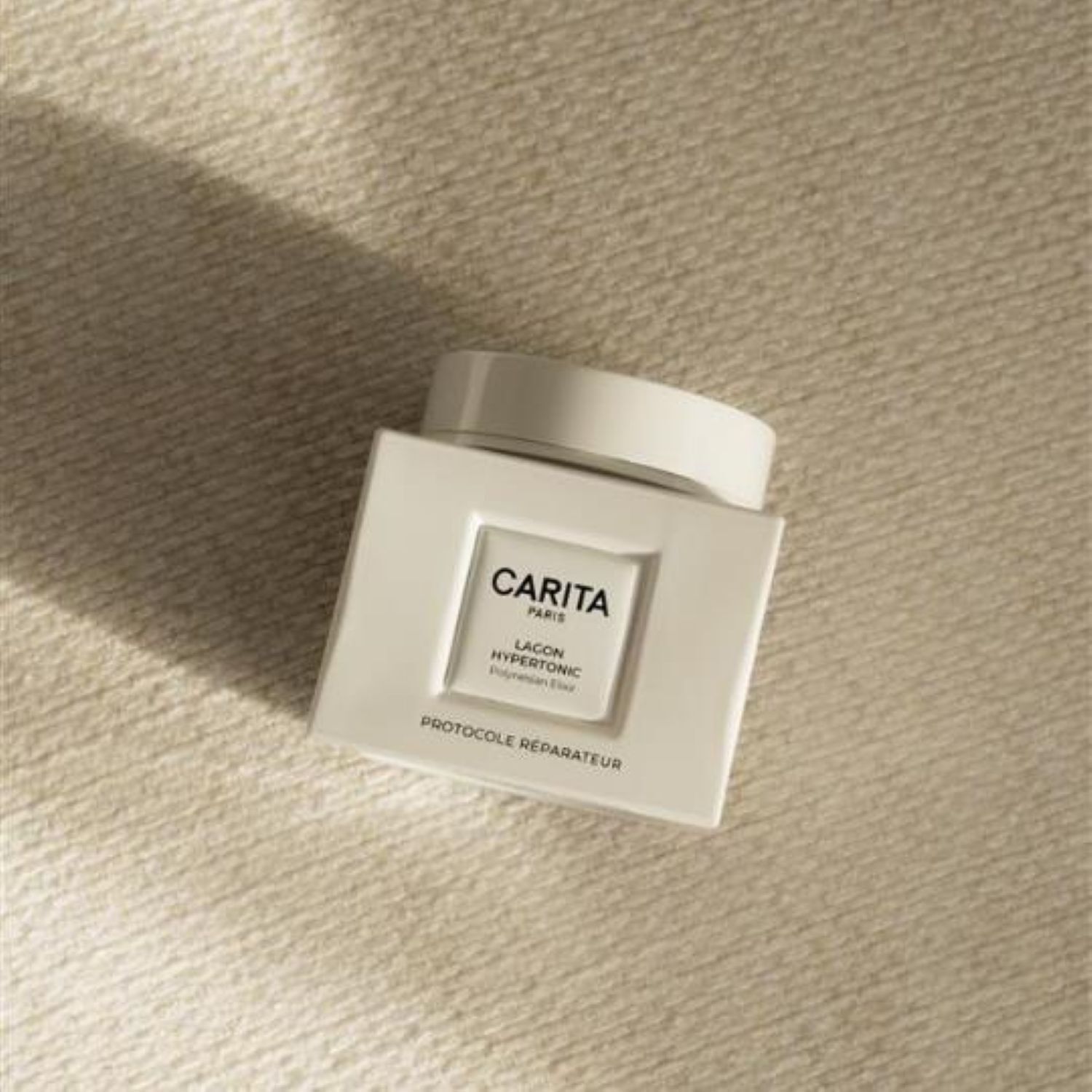Pot blanc de l'Elixir Polynesien Carita Paris Lagon Hypertonic, mentionnant 'Protocole Reparateur', concu pour la reparation et le rajeunissement de la peau 