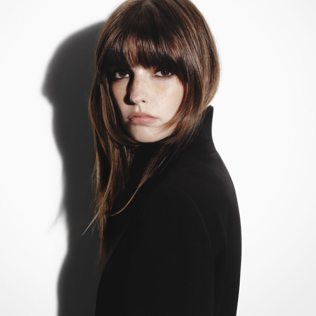 Femme brune a frange avec un brushing soyeux Hair Rejuvenic.