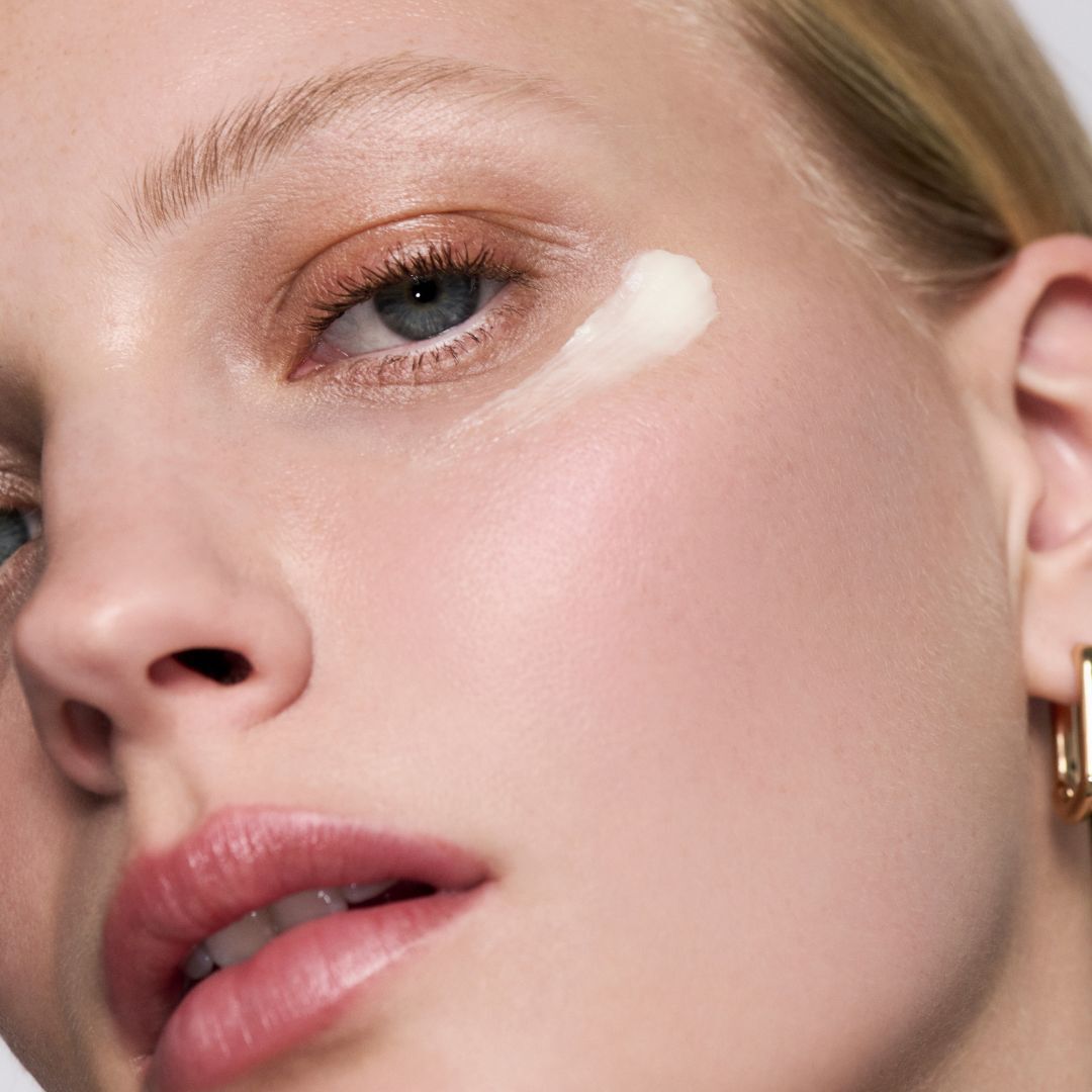 Application d'une touche de creme sur la pommette d'une femme.