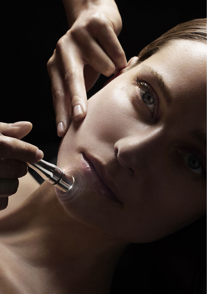 Photographie d'une jeune femme recevant un soin Carita avec la technologie aquadeep sur le visage