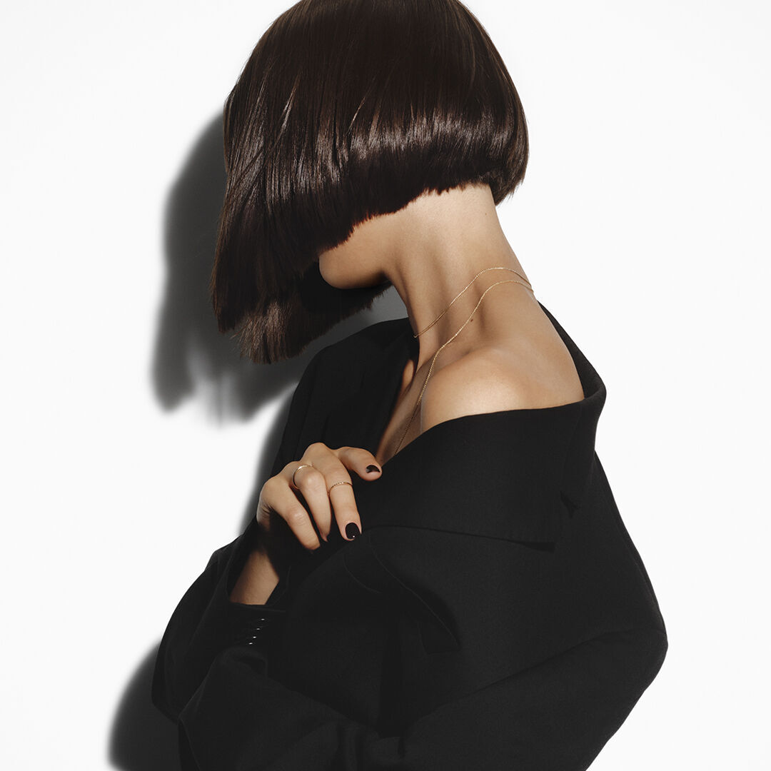 Femme brune a frange avec un brushing soyeux Hair Rejuvenic.