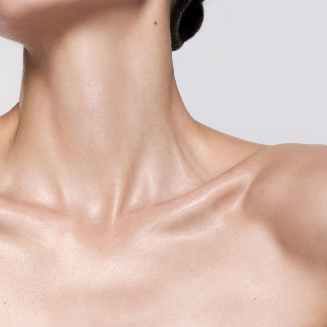 Gros plan sur le cou et la clavicule nus et illumines d'une femme.
