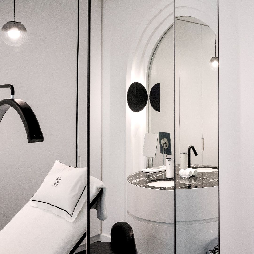 Studio du regard moderne et elegant avec un fauteuil de soins, des miroirs et un lavabo en marbre. L'espace est lumineux et presente un design epure.