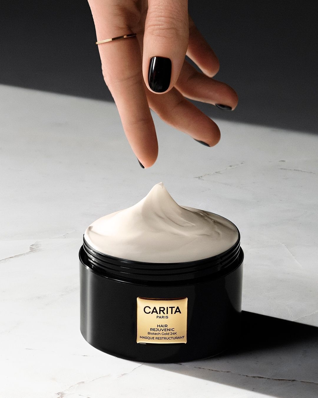 Main prelevant de la creme dans le pot de masque Hair Rejuvenic.