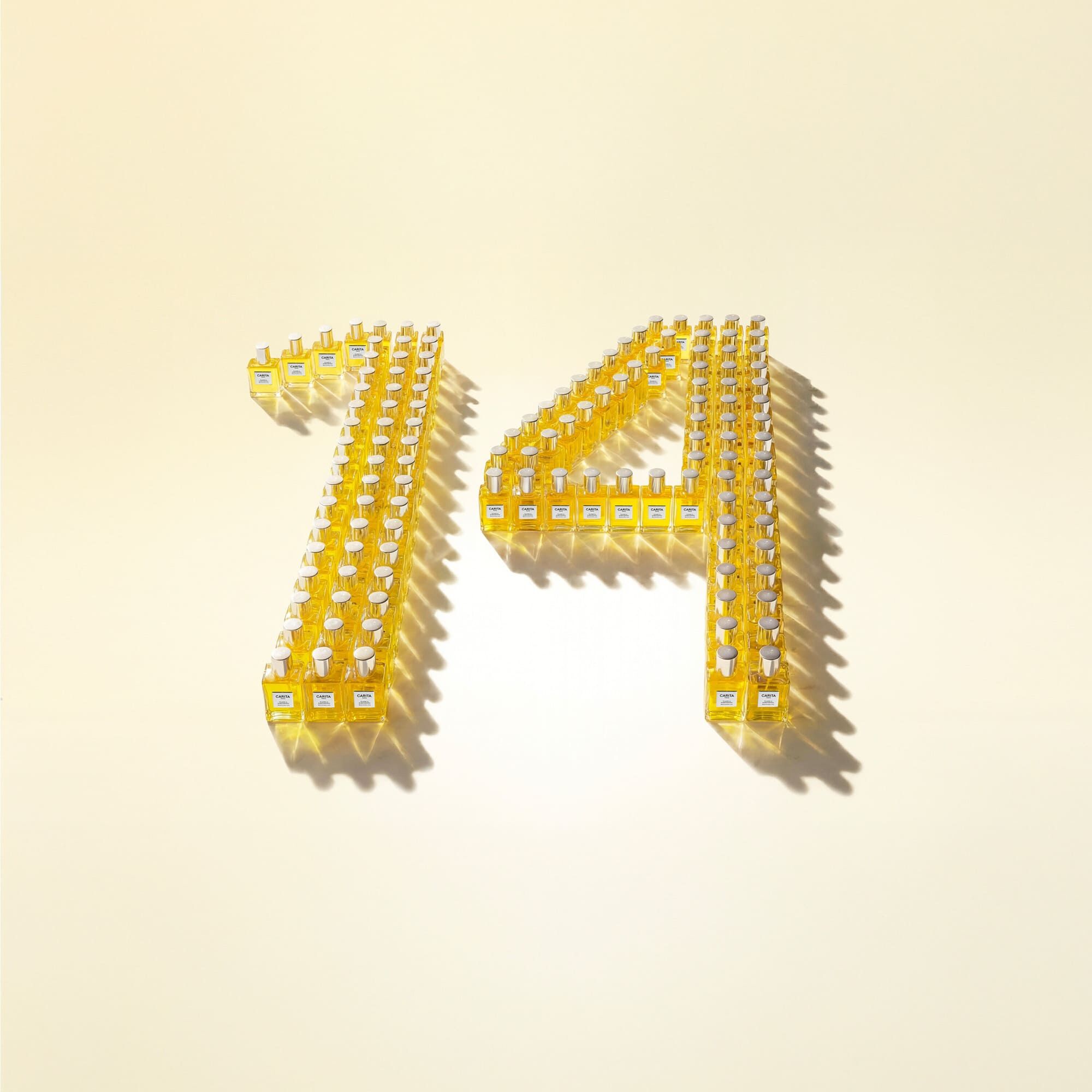 Installation artistique des flacons Carita formant le chiffre 14. Une mise en scene graphique et luxueuse celebrant l icone de la Maison dans un eclat d or et de lumiere.