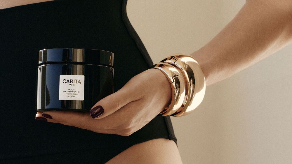Femme en maillot de bain tenant le pot Body Metamorphic.