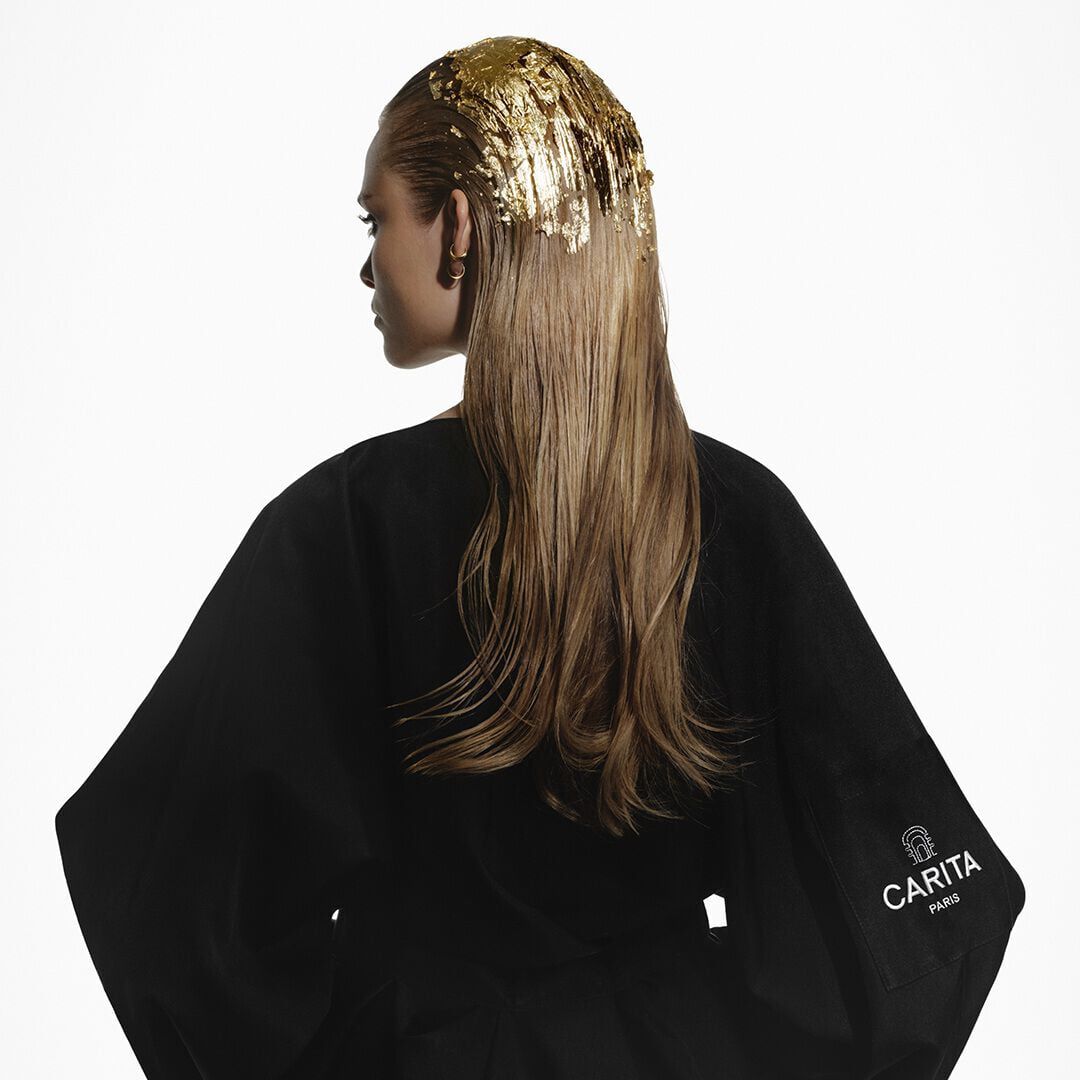 Femme blonde coiffee de feuilles d or en peignoir noir Carita.